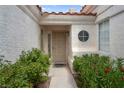 Inviting front entryway with security door, surrounded by mature greenery and a decorative round window at 4628 Standing Bluff Way, Las Vegas, NV 89130