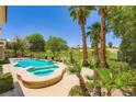 Beautiful backyard pool with a spa, palm trees, and views of the green golf course at 4719 Riva De Romanza St, Las Vegas, NV 89135