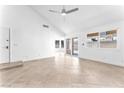 Bright living room with tile flooring, vaulted ceilings, a fan, and sliding glass doors at 6717 Sheffield Dr, Las Vegas, NV 89108