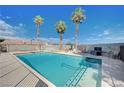 Backyard oasis with a spacious pool and spa, surrounded by tall palm trees at 6821 Jeanette St, Las Vegas, NV 89131