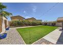 Spacious backyard featuring artificial grass, gravel, and mature foliage at 7382 Elbridge Way, Las Vegas, NV 89113