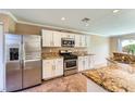 Well-lit kitchen with white cabinets and stainless steel appliances at 7382 Elbridge Way, Las Vegas, NV 89113