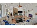 Spacious living room with a stone fireplace, wood floors, and comfortable seating at 7408 Via Fiorentino St, Las Vegas, NV 89131