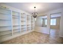 Bright room features tile floors, a built-in bookshelf and a modern chandelier at 10449 Yew Blossom Ave, Las Vegas, NV 89166