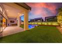 Inviting outdoor space featuring a built-in grill, pool, turf, covered patio, and privacy wall at 10748 Steel Ridge Ct, Las Vegas, NV 89135