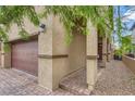 Close up of a home's exterior showing a brown brick driveway and an attached two-car garage at 10974 Cheshire Woods Ave, Las Vegas, NV 89166