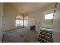 Spacious living room with a fireplace, a vaulted ceiling and access to the staircase at 1436 Padre Bay Dr, Las Vegas, NV 89108