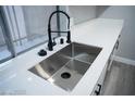 Close-up shot of a stainless steel sink and black faucet against white quartz countertops at 1440 Vegas Valley Dr # 3, Las Vegas, NV 89169