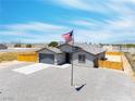 Beautiful single-story home with a spacious driveway and a flag proudly displayed in the well-maintained front yard at 1500 E Laguna St, Pahrump, NV 89048