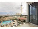 Balcony view overlooking the Stratosphere, a swimming pool, and the city landscape through a sliding glass door at 200 W Sahara Ave # 910, Las Vegas, NV 89102