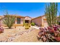 Beautiful desert landscaping with vibrant cactus and rock features enhances the home's curb appeal at 2106 King Mesa Dr, Henderson, NV 89012