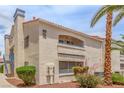 Condo building exterior featuring red tile roof, balconies, and landscaped grounds, complemented by mature palm trees under a blue sky at 2725 S Nellis Blvd # 2168, Las Vegas, NV 89121