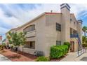 Exterior view of a low-rise condo with balconies, a red tile roof, blue railing, with a landscaped ground under a cloudy sky at 2725 S Nellis Blvd # 2168, Las Vegas, NV 89121