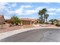 Charming single-story home with a desert landscape, tile roof, and attached two-car garage at 3109 Moongold Ct, Las Vegas, NV 89134