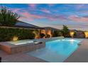 Backyard features a sparkling pool, relaxing spa, and inviting outdoor seating area under a colorful evening sky at 6192 Lautman Ridge Ct, Las Vegas, NV 89141