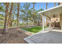 An outdoor patio with lush green lawn and mature trees offers serene views at 62 Myrtle Springs Ct, Las Vegas, NV 89148