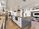 Modern kitchen featuring a large island, white cabinets, and stainless steel appliances and hardwood floors at 6639 Tranquil Seas Ct, Las Vegas, NV 89139