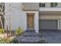 Charming townhome entrance featuring a covered entry and a two-car garage at 6952 Crescent Gold St, North Las Vegas, NV 89086