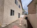 Low maintenance backyard with rock landscaping, a small patio, and a partial fence at 7249 Linaria Rd, Las Vegas, NV 89113