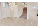 Inviting entryway features tile floors, a staircase with carpeted steps, and a view of the living area at 7711 Lofty Hill Ct, Las Vegas, NV 89123