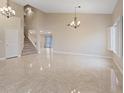 Spacious living room with staircase, tile floors, white walls, and abundant natural light at 7711 Lofty Hill Ct, Las Vegas, NV 89123
