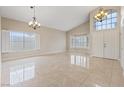 Bright living room boasts high ceilings, stylish chandeliers, tile floors, and large windows with shutters at 7711 Lofty Hill Ct, Las Vegas, NV 89123