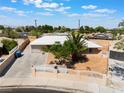 Inviting exterior of a single-story home with a private yard, palm tree, decorative fence, and desert landscaping at 829 Dover Pl, Las Vegas, NV 89107