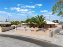 Charming single-story home featuring a well-maintained yard with a white decorative fence and stucco walls at 829 Dover Pl, Las Vegas, NV 89107