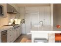Modern white kitchen with stainless steel appliances, quartz counters and breakfast bar seating at 9 Knob Oak Dr, Henderson, NV 89052