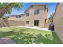 Backyard featuring lush artificial grass, patio, and privacy wall at 9105 White Eyes Ave, Las Vegas, NV 89143