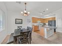 Bright kitchen with stainless steel appliances, an island with sink, and adjacent dining area at 9105 White Eyes Ave, Las Vegas, NV 89143