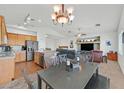 Spacious living room with modern light fixtures, open floor plan, neutral walls, and an eat-in kitchen at 9105 White Eyes Ave, Las Vegas, NV 89143