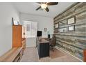 Cozy home office with wood-look accent wall, built-in shelving, and a bright window at 9105 White Eyes Ave, Las Vegas, NV 89143
