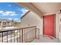 Balcony view with a red door and wrought iron railing overlooking a parking area at 950 Seven Hills Dr # 124, Henderson, NV 89052