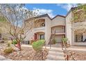 Charming condo featuring a landscaped front yard and a two-story building facade, with easy stair access to the upper units at 950 Seven Hills Dr # 124, Henderson, NV 89052