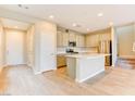 Bright kitchen featuring an island, stainless steel appliances, light cabinets, and wood-look flooring at 11840 Pelican Butte Ave, Las Vegas, NV 89138