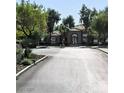 Community clubhouse and entrance to gated community with lush landscaping and paved roads at 2041 Hussium Hills St # 104, Las Vegas, NV 89108
