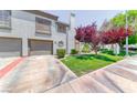 Two-story home features a two-car garage, manicured lawn, and mature trees in a desirable community at 208 Genesee Point St, Henderson, NV 89074