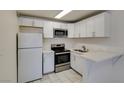 Well-lit kitchen featuring stainless steel appliances, white cabinets, and modern countertops at 212 Orland St # 28, Las Vegas, NV 89107