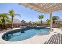 Inviting backyard pool surrounded by lush palm trees and a shaded pergola at 2221 River Grove Dr, Henderson, NV 89044