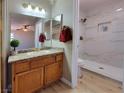 Cozy bathroom featuring a marble tiled shower, granite countertop vanity, and wood plank flooring at 2451 Muirfield Ave, Henderson, NV 89074