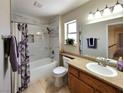 Bright bathroom with a shower/tub combo, granite countertop vanity, and a framed mirror at 2451 Muirfield Ave, Henderson, NV 89074