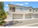 A well-maintained two-story townhome with a private balcony and two-car garage under a blue sky at 2860 Sunflower Days Ave # 2141, North Las Vegas, NV 89031