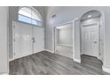 Bright foyer with soaring ceilings, gray wood-look tile flooring, and a large arched window above the double front doors at 3425 Bedfordshire Pl, Las Vegas, NV 89129