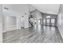 Spacious living room boasting high ceilings, gray wood-look flooring, a staircase, and ample natural light at 3425 Bedfordshire Pl, Las Vegas, NV 89129