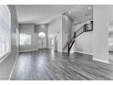 Bright living room with tall ceilings, wood-look floors, a staircase, and an arched doorway to the entrance at 3425 Bedfordshire Pl, Las Vegas, NV 89129