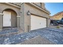 Close up of a home's driveway and entrance with stone pavers and a well maintained two car garage at 377 Yellow Finch Ln, Henderson, NV 89012
