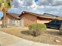Exterior view of the house, with a manicured lawn, desert landscaping, and a two car garage in the desert at 3936 Rive Gauche St, Las Vegas, NV 89115