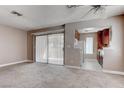 Living room with neutral walls, carpet, and view into the kitchen; backyard access via sliding glass door at 4860 Nara Vista Way # 104, Las Vegas, NV 89103