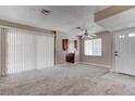 Living room with neutral walls, carpet, ceiling fan, and view into the kitchen and access to the backyard at 4860 Nara Vista Way # 104, Las Vegas, NV 89103
